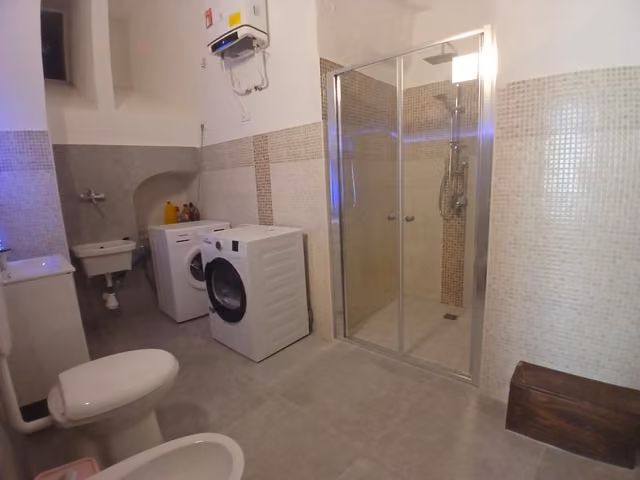 Bagno con doccia e lavatrice