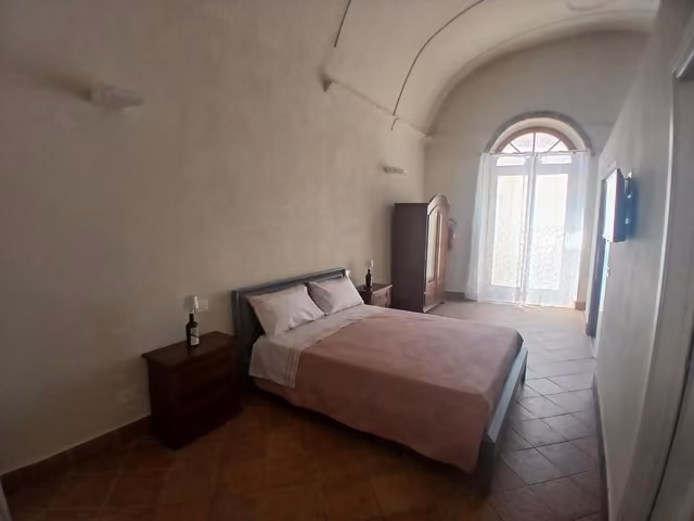 Camera da letto con letto e grande finestra di Tursi Relais Virtus