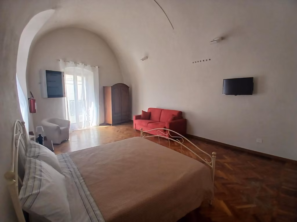 Camera da letto con letto e sedia rossa a Tursi Relais Virtus