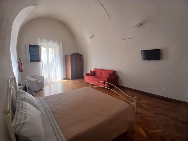 Camera da letto con letto e sedia rossa a Tursi Relais Virtus